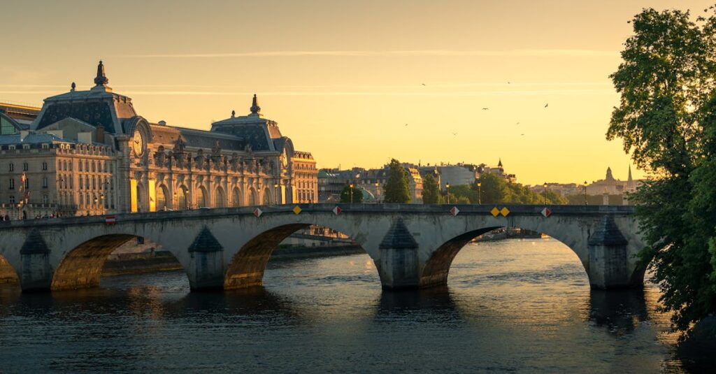 Arch Bridge Over a River Near a Concrete Building