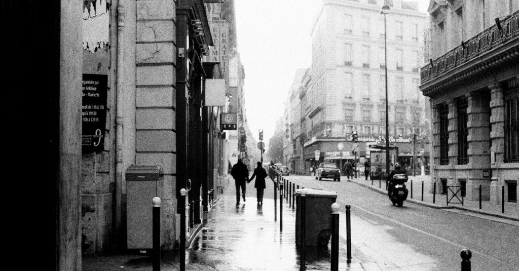 Black and White Photo of Couple Walking Through City